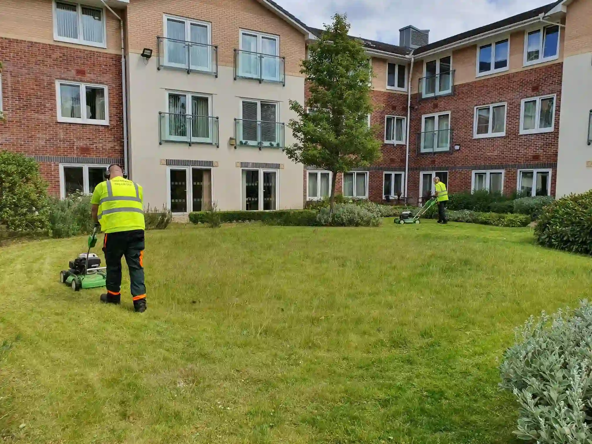 Grounds maintenance team maintaining a residential development lawn as part of ecological solutions and sustainable landscape management.